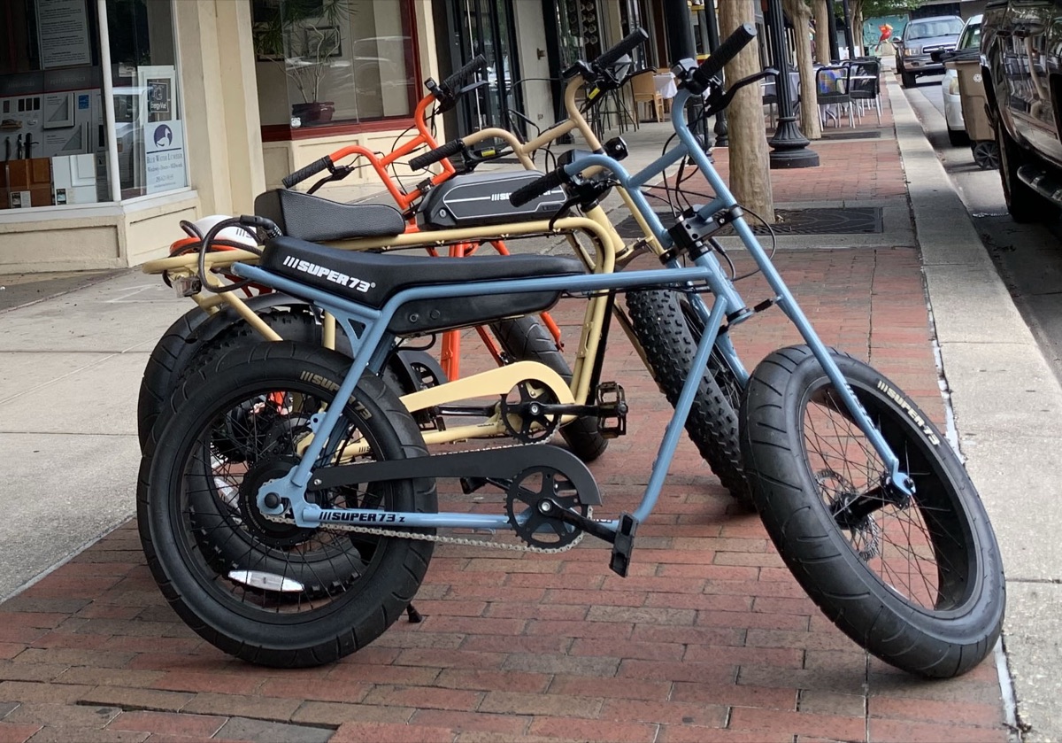 Row of Super73 electric bikes parked on a downtown Pensacola sidewalk
