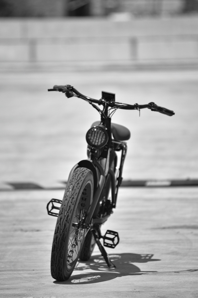 Close-up of a folding electric bike parked against a brick wall