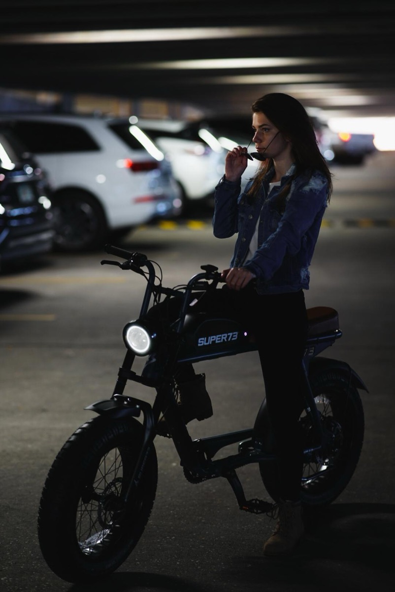 Rider with a Super73 electric bike lit up at night in a Pensacola parking garage
